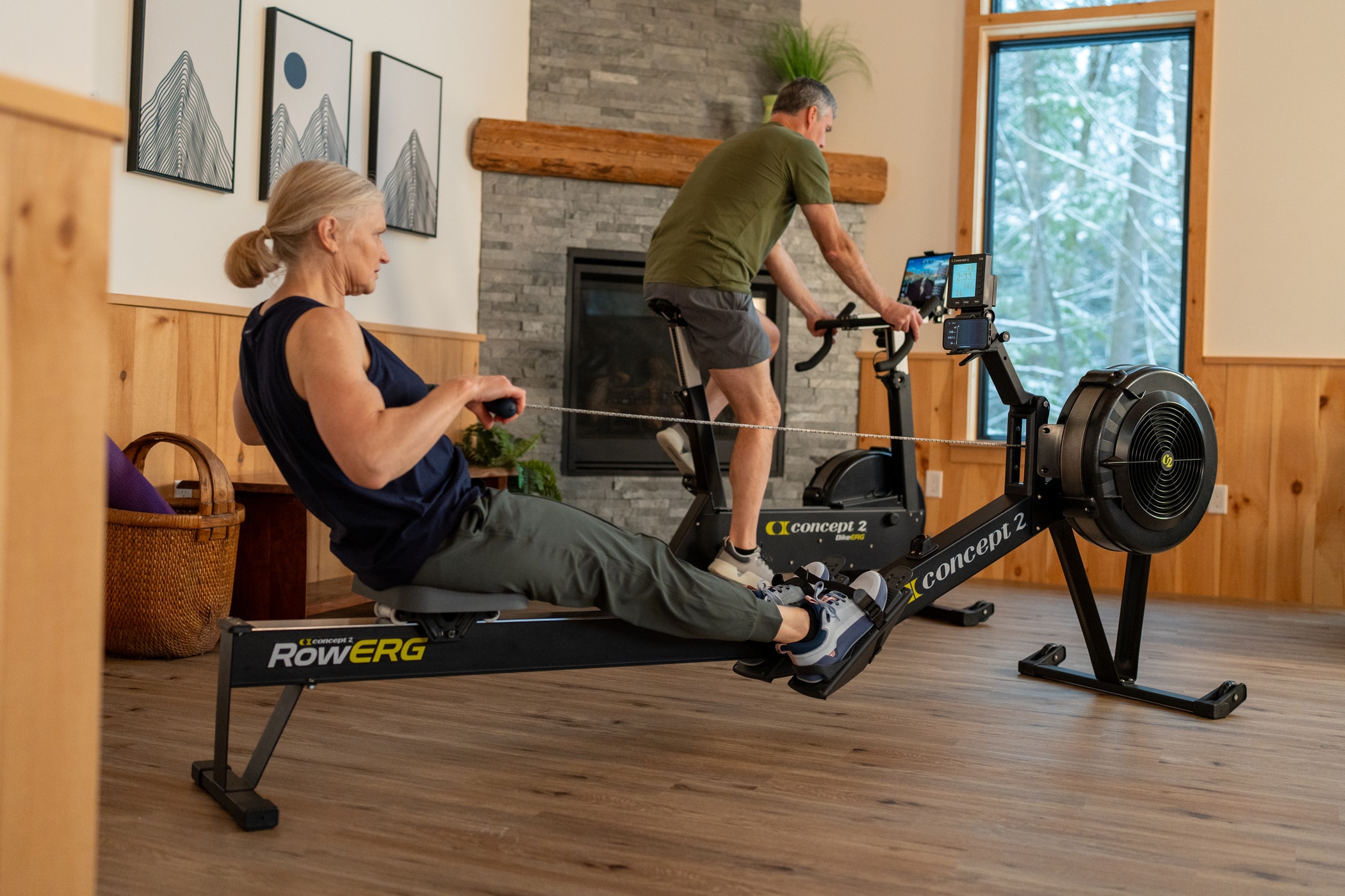 Woman on a RowErg while a man is on a BikeErg